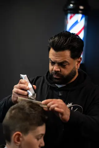 Barber using clippers and a comb during a haircut