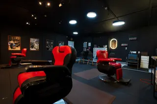 Red barber chairs in a dark, modern barbershop