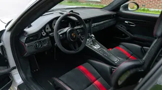 Sports-car cockpit with dark seats and red accents