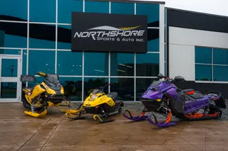 Snowmobiles displayed outside a glass-fronted dealership