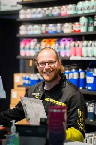 Smiling person behind a retail counter