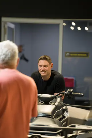 Person speaking with a visitor across a showroom counter