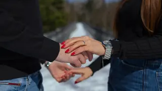 Close view of a couple’s hands and engagement ring