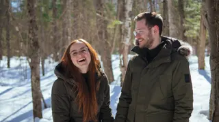 Couple laughing together in a snowy forest