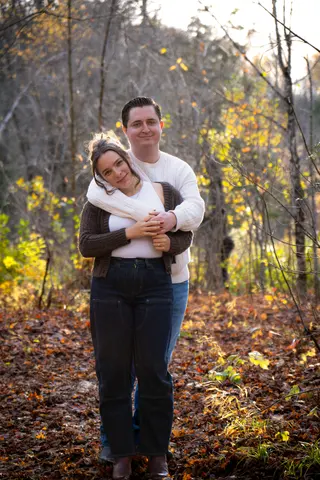 Couple embracing among autumn leaves