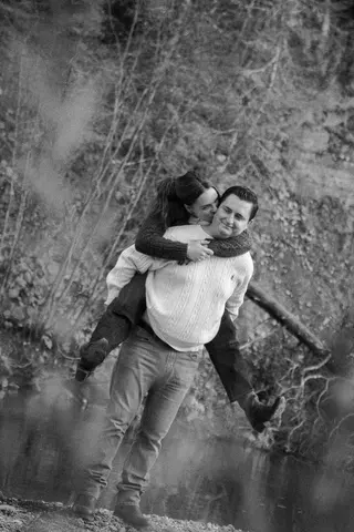 Black-and-white photograph of a playful piggyback ride outdoors