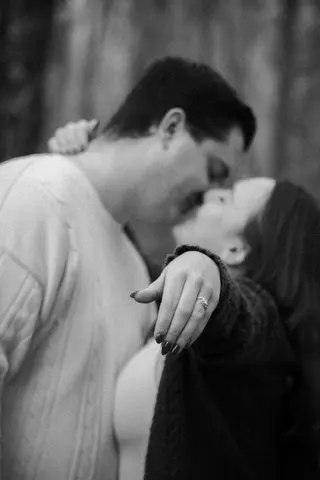 Close black-and-white portrait of a couple kissing