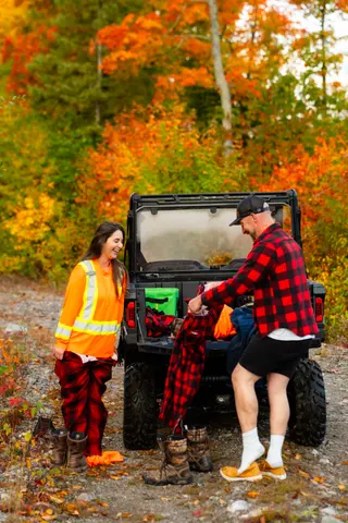 Couple beside an off-road vehicle on a colourful autumn trail