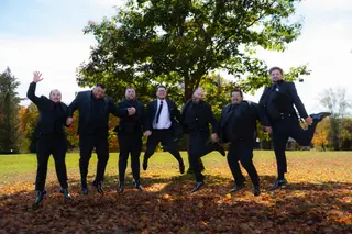 Groomsmen jumping together on an autumn lawn