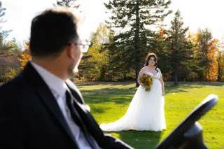 Bride approaching the groom on a green lawn