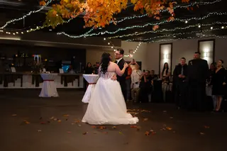 Newlyweds dancing beneath string lights at their reception