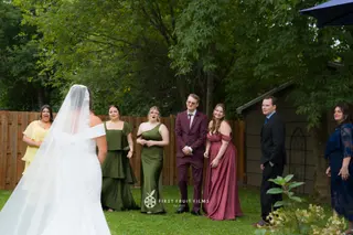 Wedding party greeting the bride in a green garden