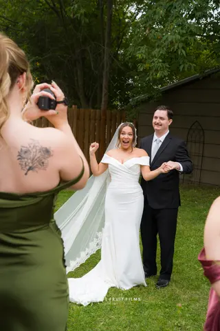 A guest photographing the newlyweds outdoors