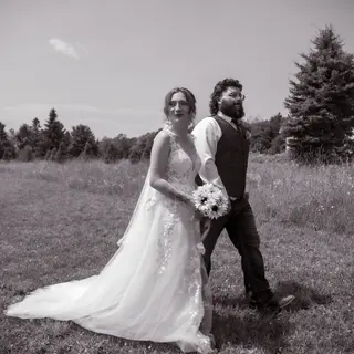 Black-and-white portrait of newlyweds in an open field