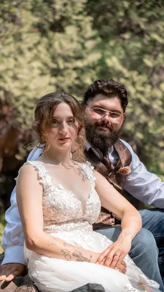 Portrait of newlyweds seated together in the shade