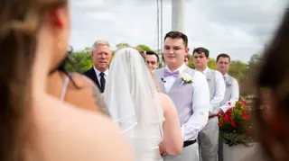 Groom looking at the bride during a waterfront ceremony