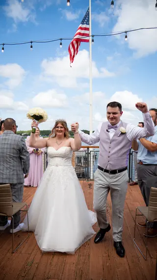 Newlyweds celebrating as they walk past their guests