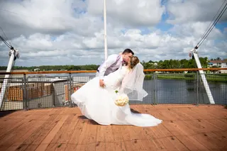 Groom dipping the bride on a wooden waterfront deck